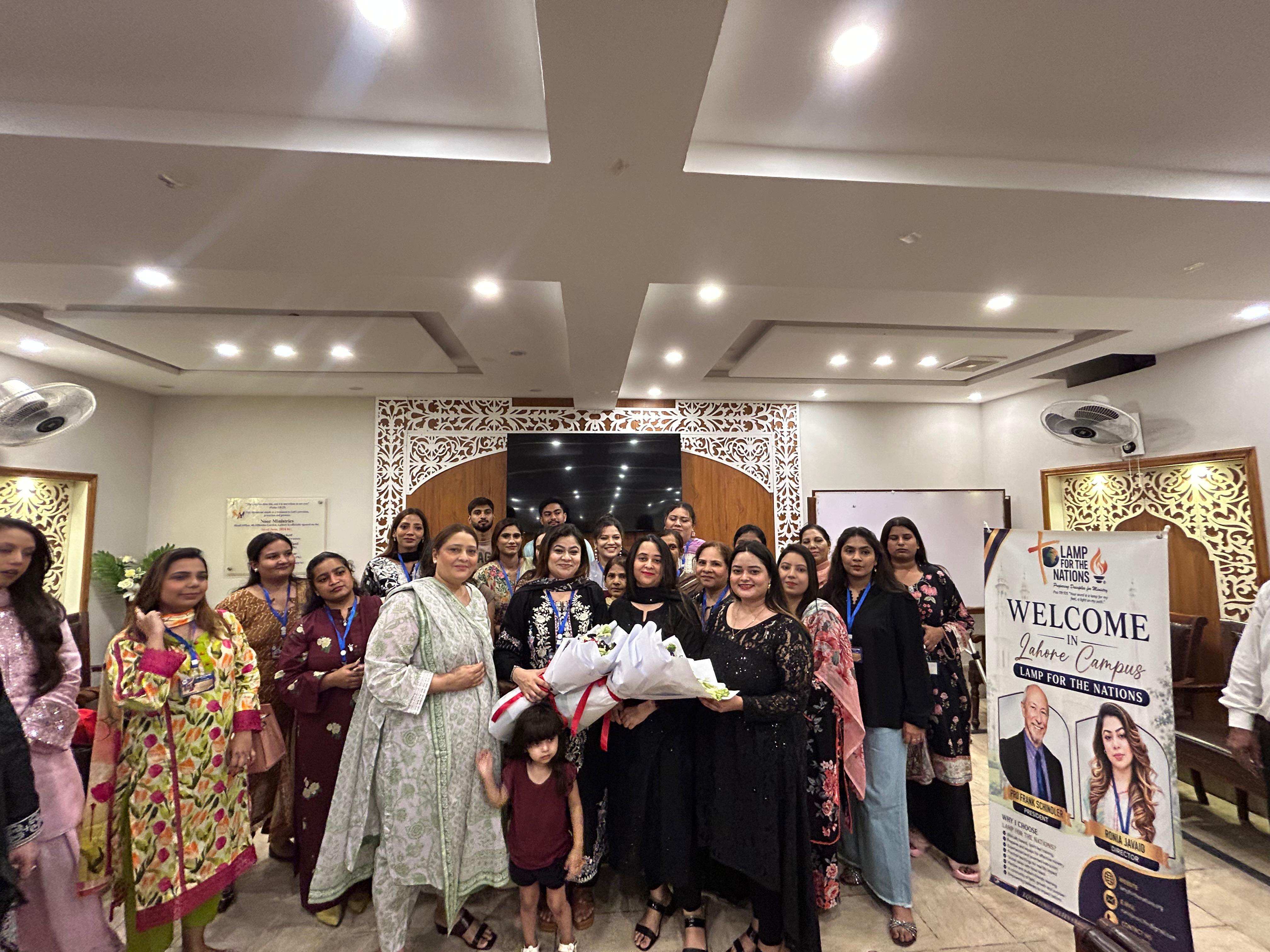 Lahore Campus students posing together, with flowers presented at the front